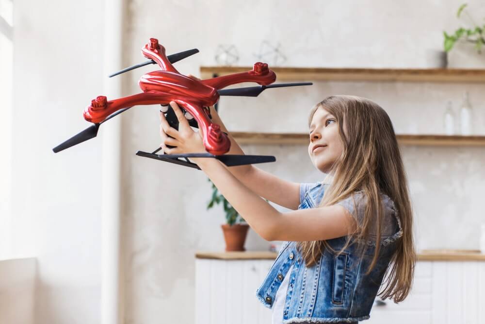 A young girl holding her favorite red drone