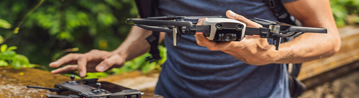 A man flying a drone in snow