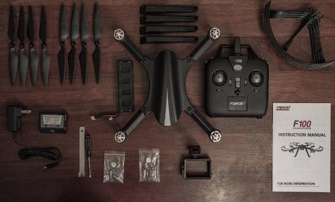 F100 Brushless Drone unboxing on wooden floor